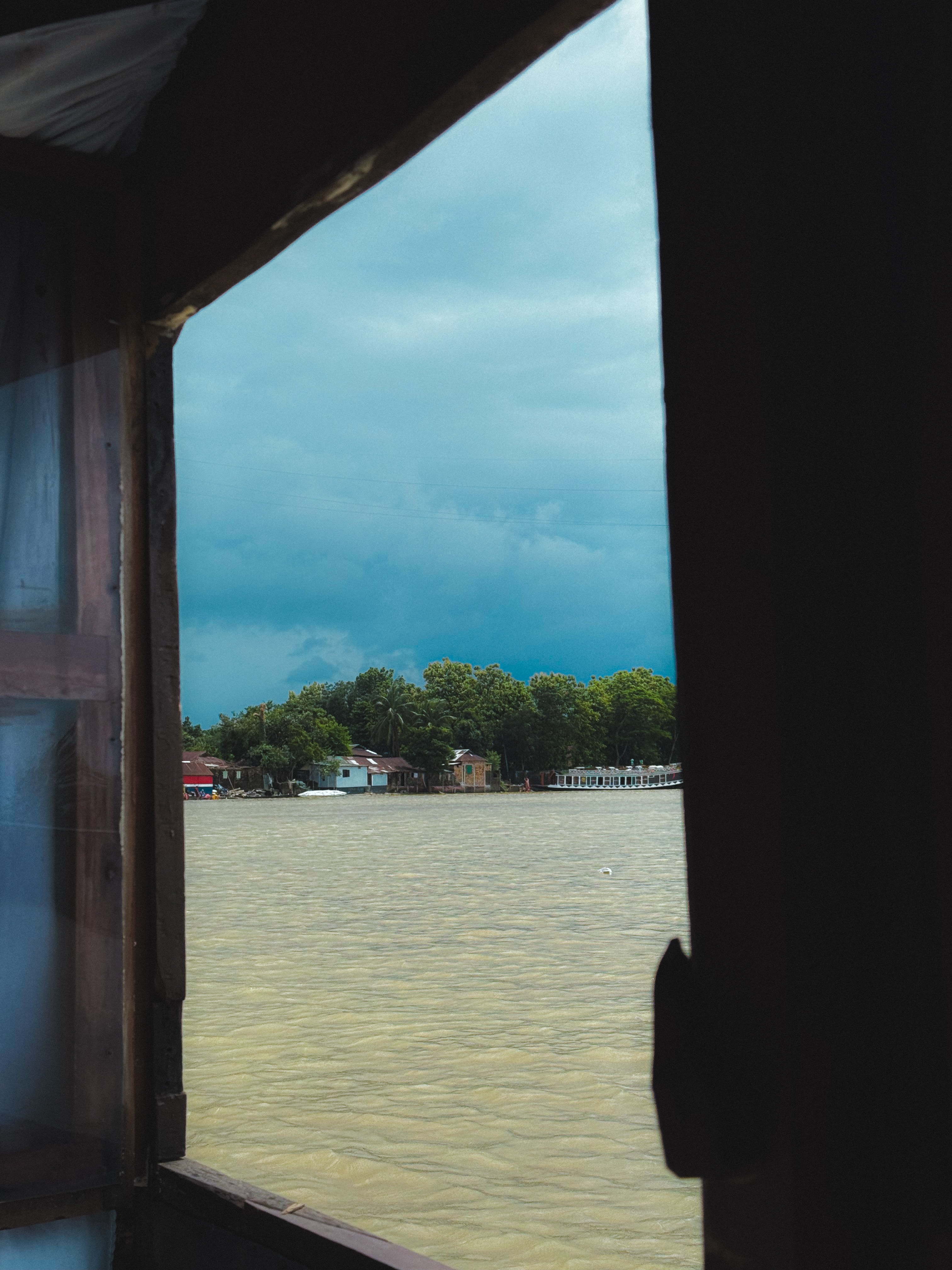 A river landscape viewed through a dark window